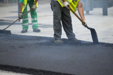 Worker operating asphalt paver machine during road construction and repairing works Choice for Road Surfacing Kent